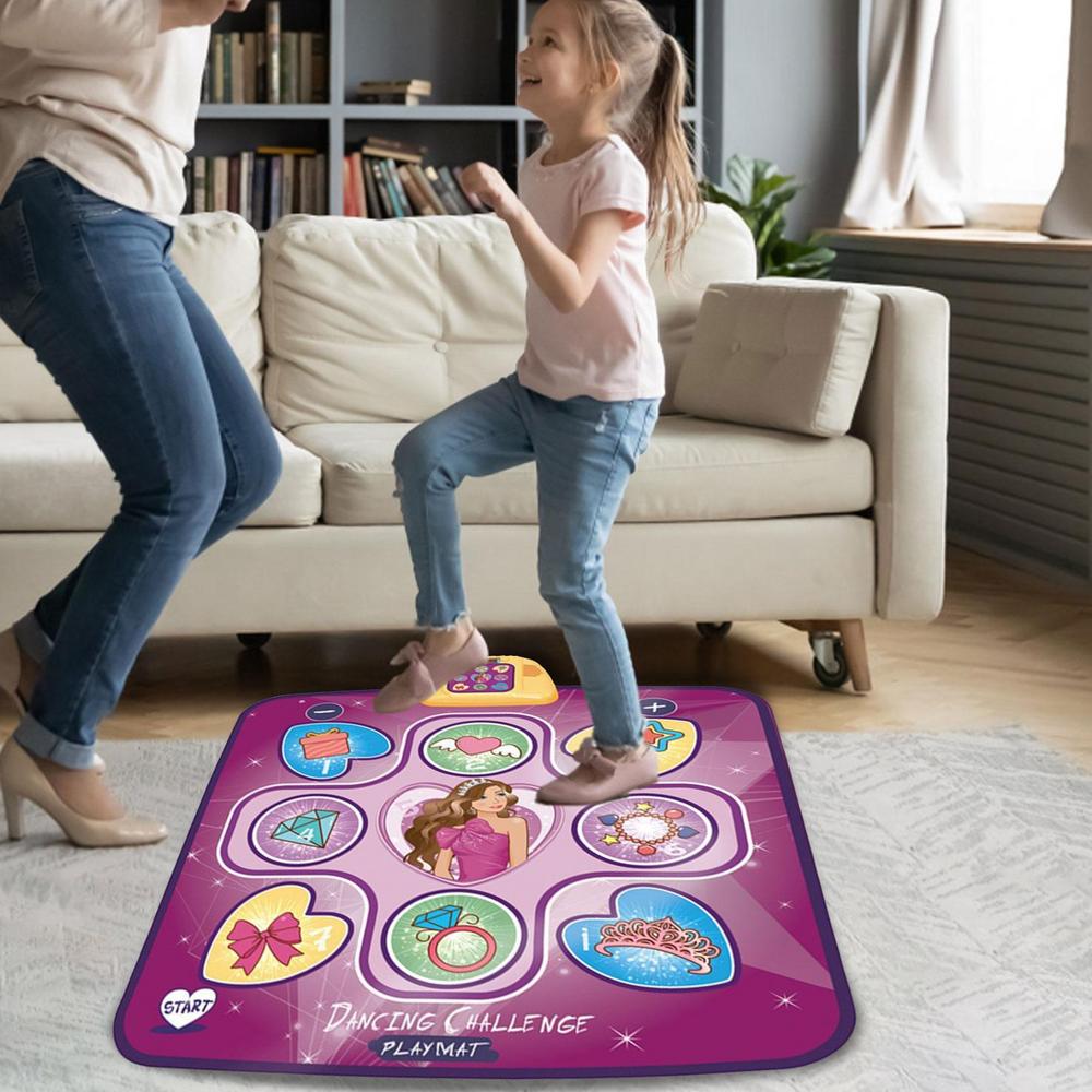 An adult and a young girl smile and dance to built-in music on the Toyfetti Interactive Dance Light Mat – LED Movement Game for Kids, in a living room with a white sofa and bookshelf in the background.