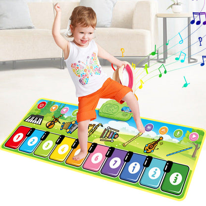 A smiling toddler in an orange outfit steps on the Toyfetti Musical Dance Piano Mat—movement and music fun for toddlers—raising one arm joyfully as musical notes float, showcasing the interactive features of this colorful play mat.