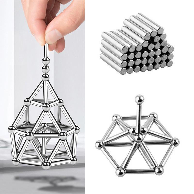 A hand lifts a geometric shape from the Toyfetti MagnoCraft – Magnetic Building Set for Creative Kids, with stacked rods and another assembled form nearby, promoting fine motor skills and spatial reasoning.