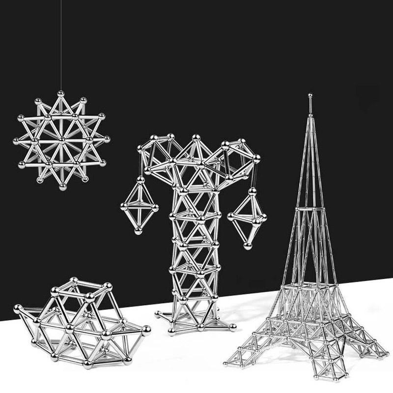 Four geometric structures—star, tree, polygon, and Eiffel Tower shapes—made from the Toyfetti MagnoCraft Magnetic Building Set for Creative Kids are arranged on a black and white background, showcasing shiny rods and spheres.