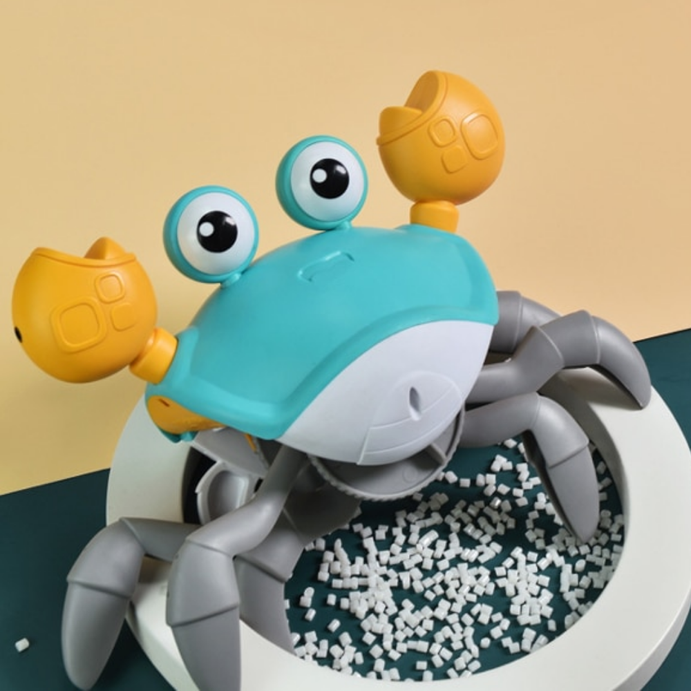 The Toyfetti HappyCrab – Crawling Companion with Lights & Music features big eyes, yellow claws, and gray legs on a white base. Perfect for tummy time, this self-moving toy delights against a yellow and teal backdrop with playful white pellets.