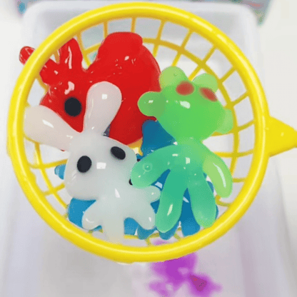 The Toyfetti Magic Water Wonder Kit features a yellow scoop holding three vibrant 3D animal toys—a red figure, a green creature, and a white bunny—offering hands-on sensory fun with just water.