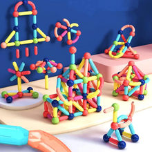 MagniBlocks™- The OG Magnetic Building Blocks by Toyfetti are assembled into rockets, flowers, and abstract designs using colorful magnetic sticks and balls, displayed on a light surface with a blue background.