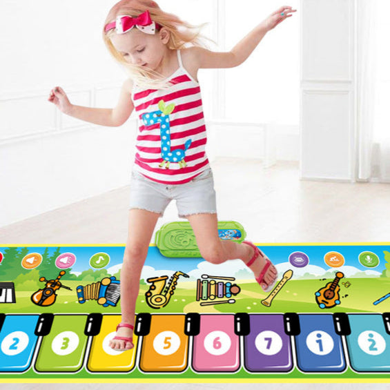 A young girl in a red striped tank top enjoys the Toyfetti Musical Dance Piano Mat – Movement & Music Fun for Toddlers, stepping on colorful, numbered keys with musical notes and instruments to play music with her feet.