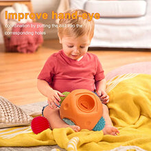 A baby plays with the Toyfetti Montessori Sensory Wonder Ball – Educational Textured Ball Set for Babies & Toddlers on a yellow blanket. Text reads, “Improve hand-eye coordination and fine motor skills by matching the ball to the correct holes.”.