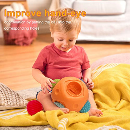 A baby plays with the Toyfetti Montessori Sensory Wonder Ball – Educational Textured Ball Set for Babies & Toddlers on a yellow blanket. Text reads, “Improve hand-eye coordination and fine motor skills by matching the ball to the correct holes.”.