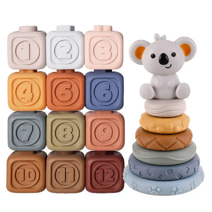The Toyfetti CubbyKoala Soft Silicone Teether & Stacking Toy Set for babies includes 12 colorful, numbered blocks and a sensory set with a smiling koala on five pastel textured rings.