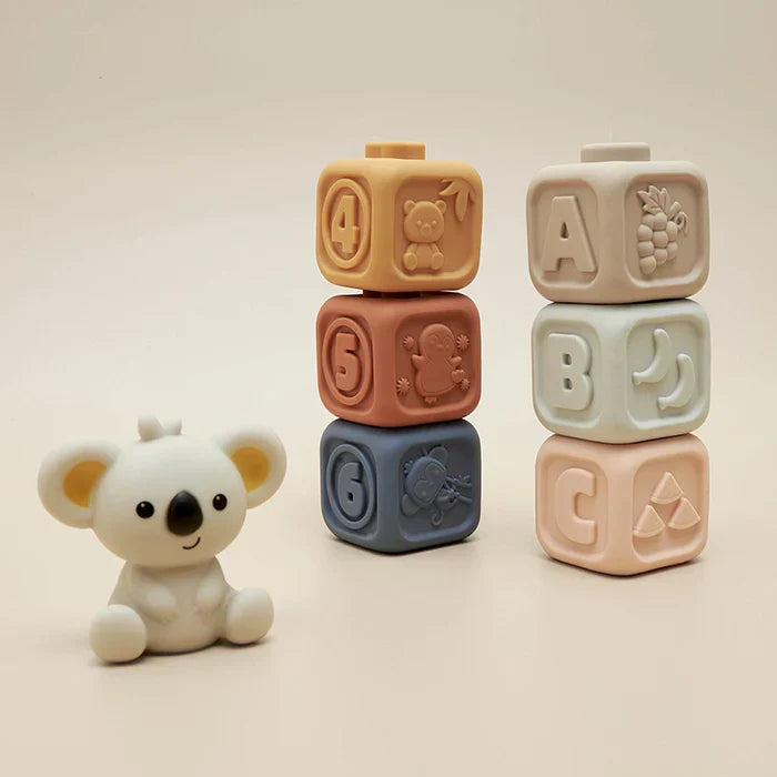 The Toyfetti CubbyKoala – Soft Silicone Teether & Stacking Toy Set for Babies features a plush koala and two colorful stacking towers with numbers, letters, and raised animal or fruit designs for playful sensory fun.