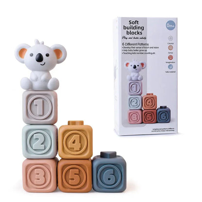 The Toyfetti CubbyKoala set includes six pastel, numbered soft silicone blocks stacked in two columns with a koala topper. This teether and stacking toy for babies is shown alongside its box.