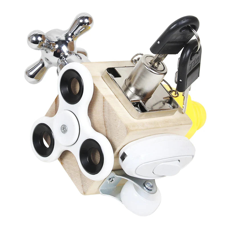 The Toyfetti Montessori Lock & Key Learning Cube is a hands-on skill toy for curious kids, featuring a black and white fidget spinner, metal key in lock, faucet handle, light switch, and caster wheel for fine motor fun.