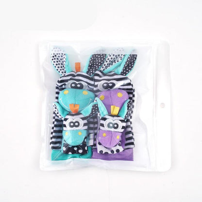 The Toyfetti Plush Animal Baby Socks & Wrist Rattle Set includes two pairs of teal and purple baby socks with soft rabbit faces, ears, black-and-white stripes, and polka dot patterns—perfect for sensory play.
