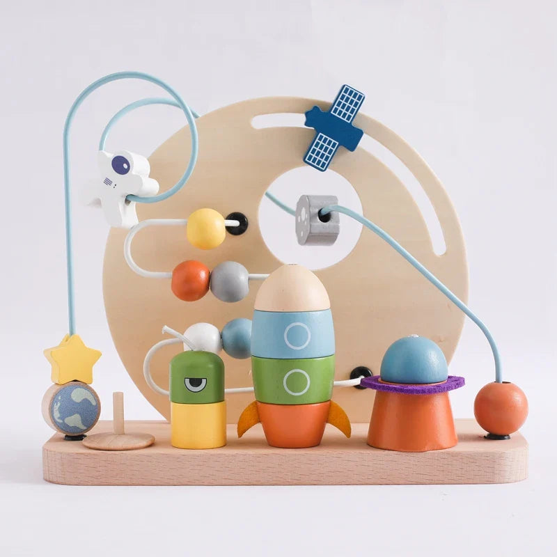 The Toyfetti Bead Tracks – Wooden Maze Toy for Early Motor Skill Development features a space-themed bead maze with planets, astronaut, green alien block, rocket, Saturn, star stand, and satellite to boost fine motor skills and coordination.
