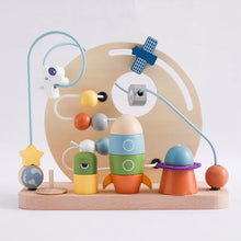 The Toyfetti Bead Tracks – Wooden Maze Toy for Early Motor Skill Development features a space-themed bead maze with planets, astronaut, green alien block, rocket, Saturn, star stand, and satellite to boost fine motor skills and coordination.