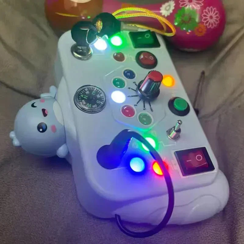 The Toyfetti BusyBoard Logic & Light Panel is a Montessori-inspired switch board with lights, buttons, switches, a compass, and an adorable animal figure—perfect for sensory play and curious kids.