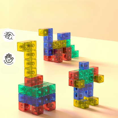 Three colorful structures built from Toyfetti’s Magnaplay | Creatief Bouwen Met Magneten - Magnetische Bouwblokken in red, yellow, green, and blue sit on a light surface. Touch icons on the left hint at interactive educatieve voordelen.