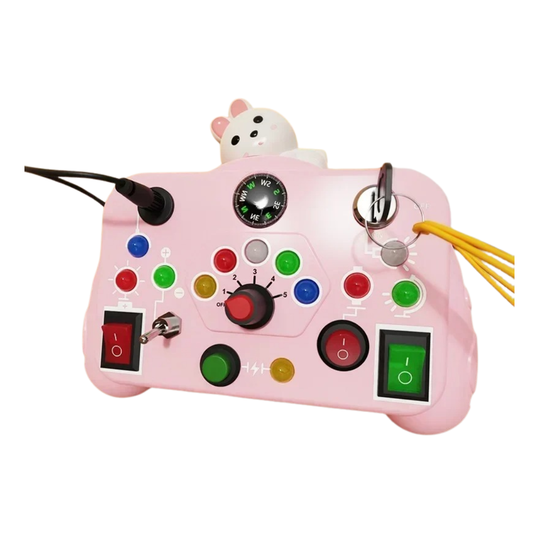 The Toyfetti BusyBoard Logic & Light Panel is a pink Montessori-inspired switch board with colorful buttons, switches, knobs, and indicator lights for sensory play. A small bear figurine sits on top, and cables connect to side ports for extra fun.
