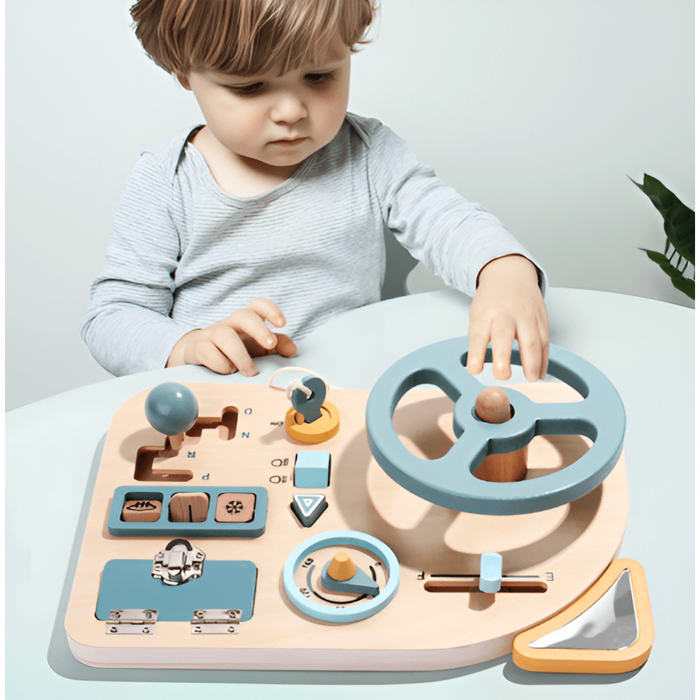 A young child explores the Toyfetti Montessori Car Press Board – Hands-On Driving Toy for Curious Toddlers, a wooden activity set with steering wheel, gear shift, switches, and dials in soft blue, ideal for building fine motor skills.