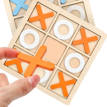 A hand places an orange X piece on the Toyfetti Wooden Tic Tac Toe for Family Fun & Home Style, with white O pieces on the board and another set in the background—ideal for game nights or stylish home décor.