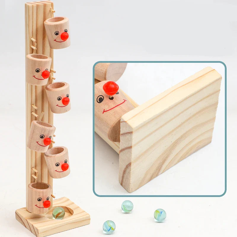 The Toyfetti Clown Track Wooden Play Tower features stacked, smiling face cups on a stand to boost fine motor skills. Three glass marbles are in front, and an inset highlights a face cup with a wooden board.