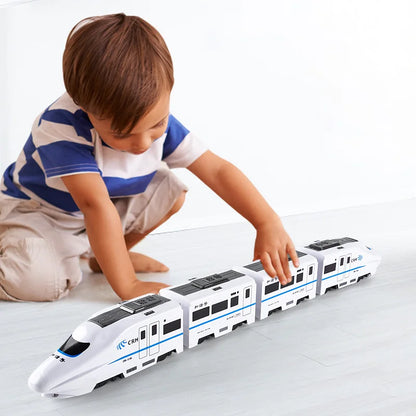A young boy in a striped shirt kneels, playing with the Toyfetti GlowExpress—an obstacle-avoiding, light-up train that glides across the floor, building his skills and spatial awareness with its magical movement.