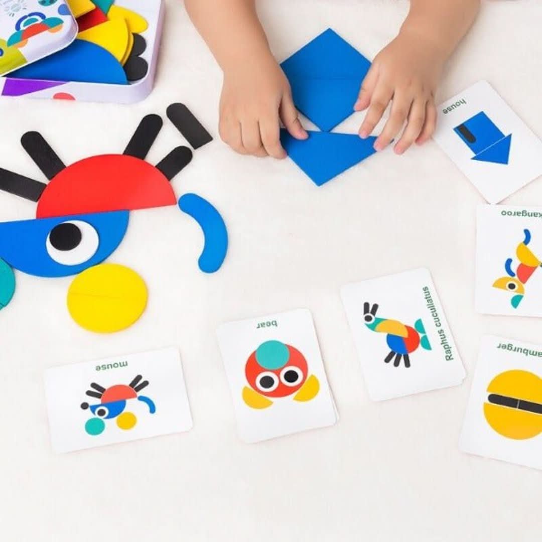 A child arranges blue geometric shapes on a table with colorful pieces and cards showing cartoon animals, enjoying Toyfetti’s Montessori Pattern Puzzle – Wooden Shape Matching Set with 60 Challenge Cards as a screen-free activity.
