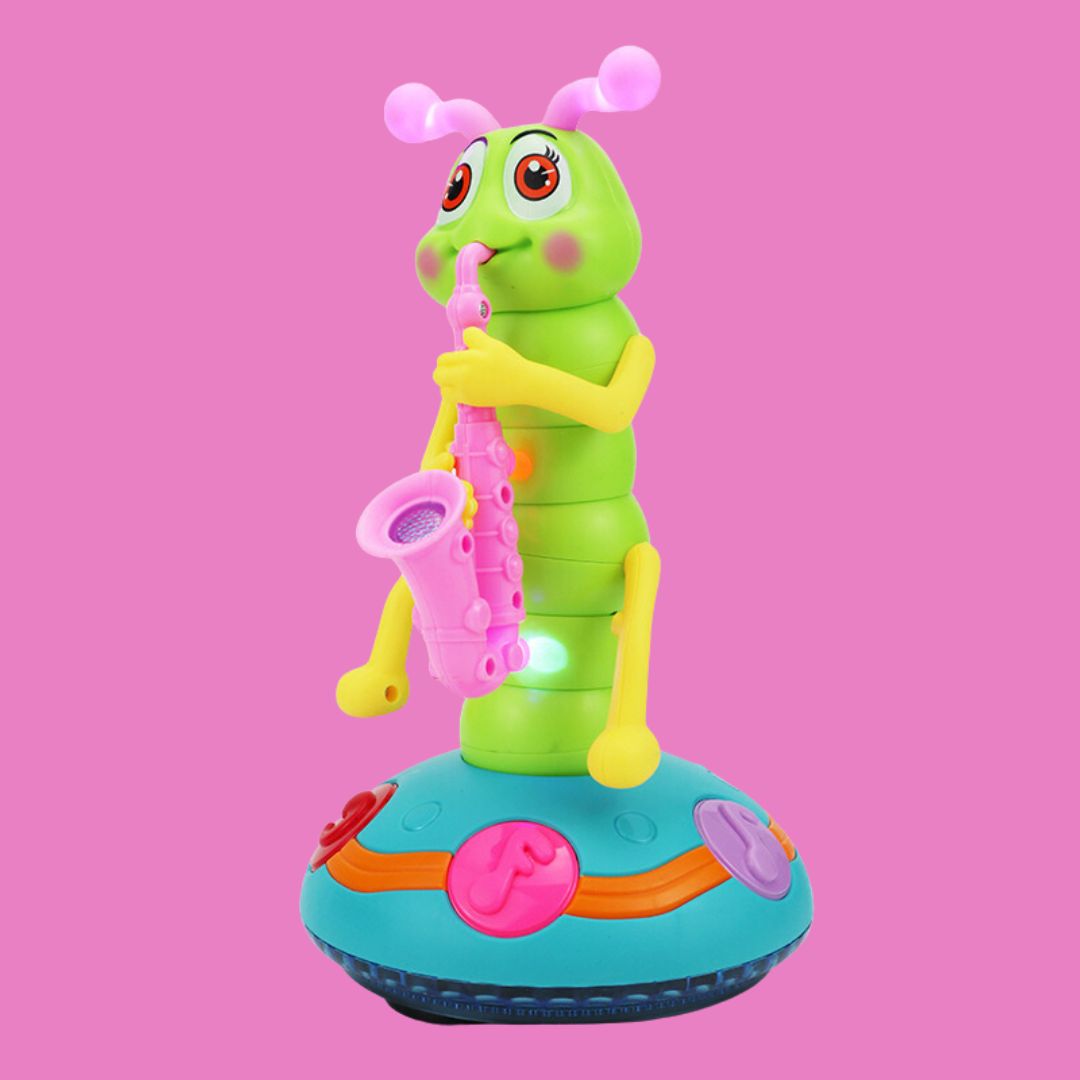 The Toyfetti Dancing Saxophone Caterpillar – Musical LED Toy for Toddlers is a green caterpillar with pink antennae, rosy cheeks, and a pink saxophone on a blue base, perfect as a colorful toddler dance toy.