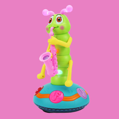 The Toyfetti Dancing Saxophone Caterpillar – Musical LED Toy for Toddlers is a green caterpillar with pink antennae, rosy cheeks, and a pink saxophone on a blue base, perfect as a colorful toddler dance toy.