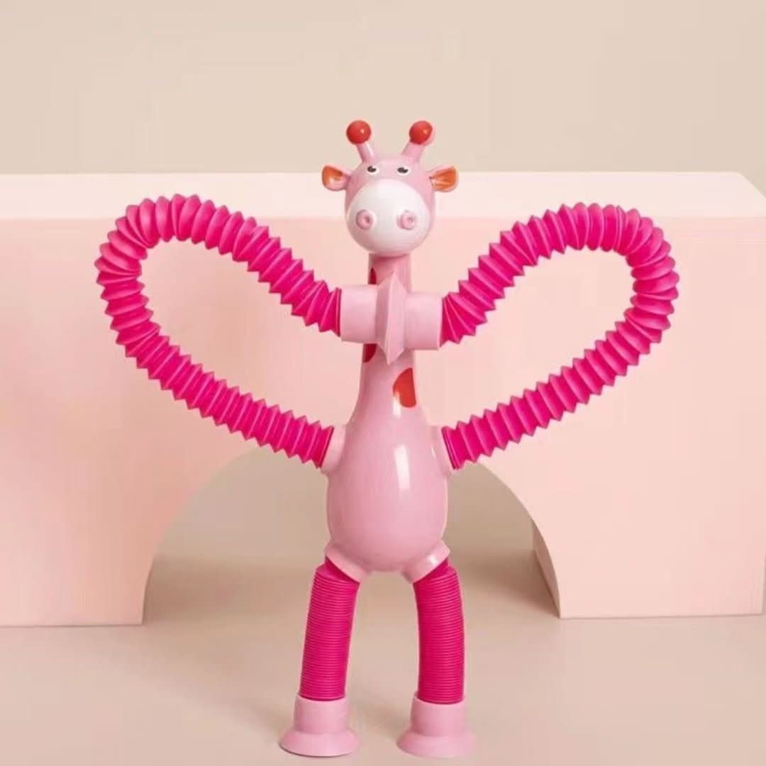 The Toyfetti Stretchy Giraffe Trio features pink bendable sensory toys with accordion-style arms and suction cups—ideal as fidget toys or cute toddler party favors against a pastel pink backdrop.
