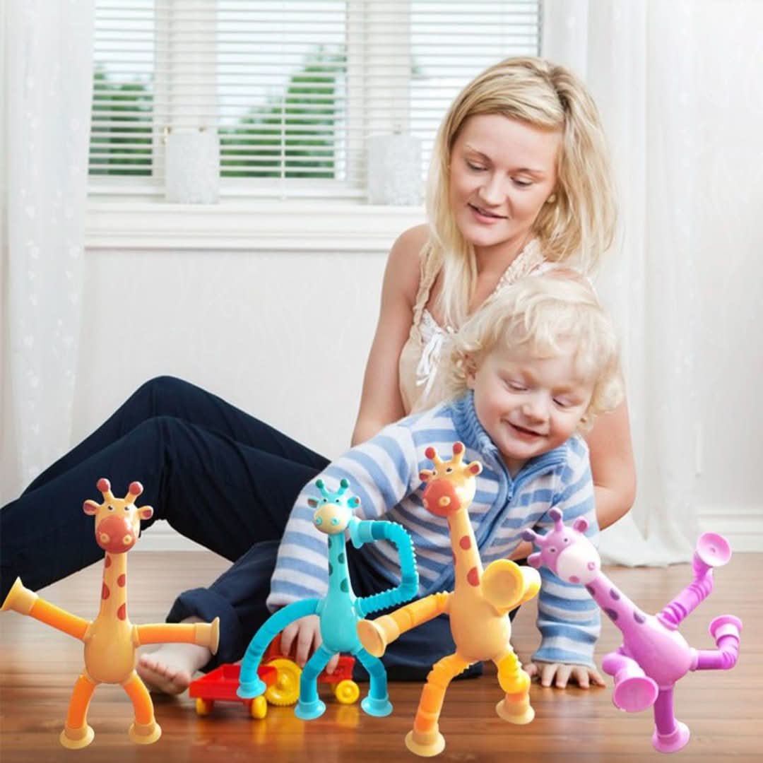 A smiling woman and child play on the floor with Toyfettis Stretchy Giraffe Trio—bendable sensory toys with suction cups—making perfect toddler party favors in a bright room with large windows.