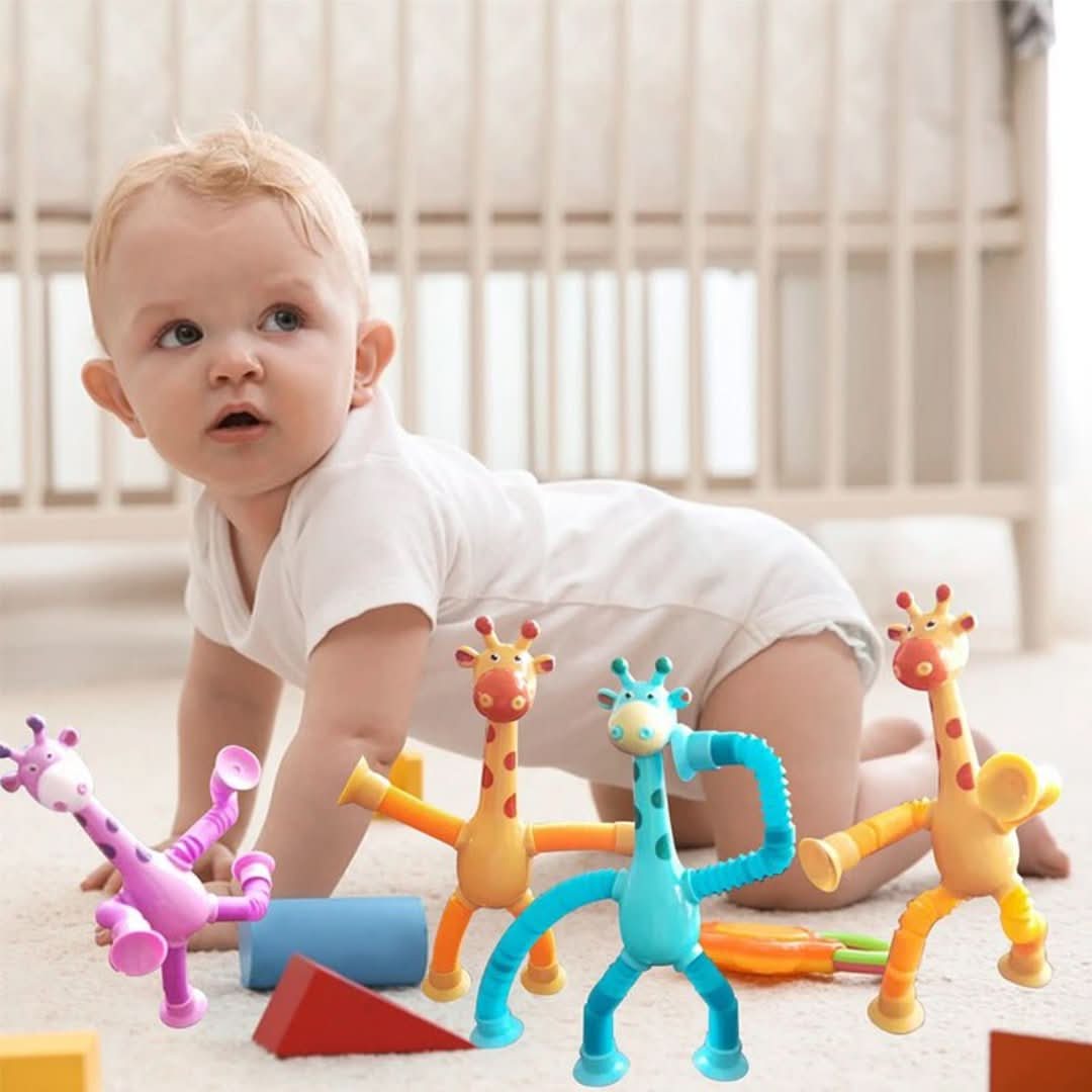 A baby in a white onesie crawls on the floor near Toyfetti’s Stretchy Giraffe Trio—bendable sensory toys with suction cups, ideal as fidget toys or toddler party favors—with a crib in the background.